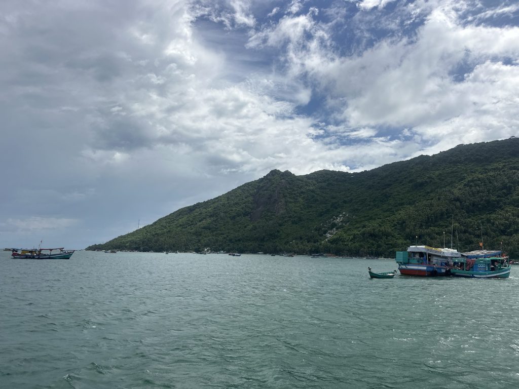 Đảo Hòn Sơn và bè nổi nhìn từ biển, thấy cả núi và làng