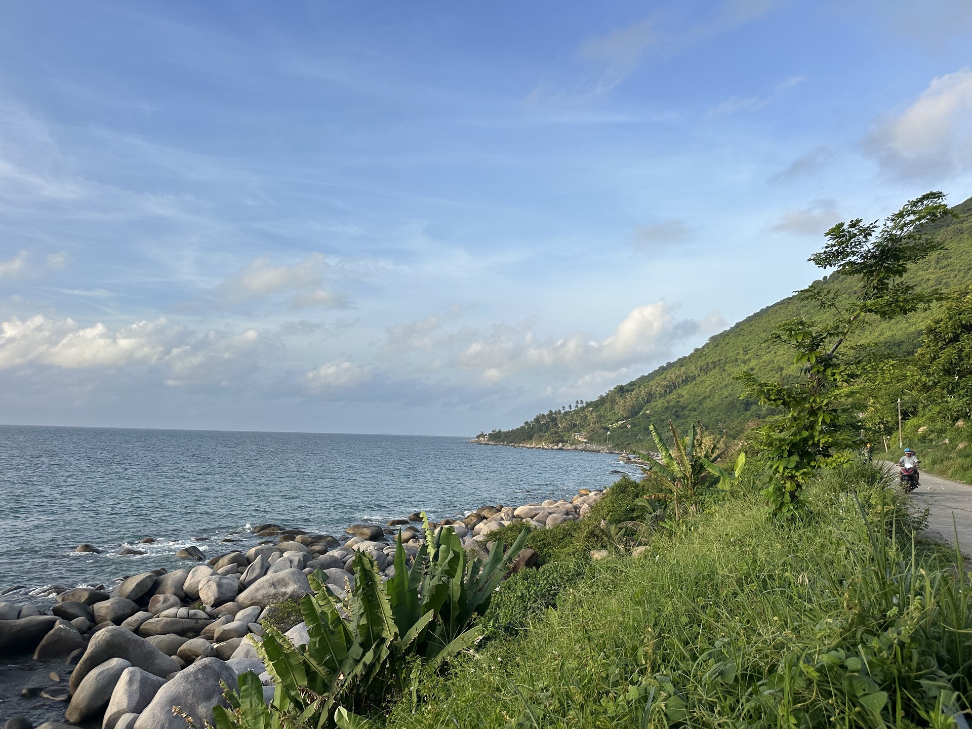 The road around the island runs along the mountainside above a boulder shore
